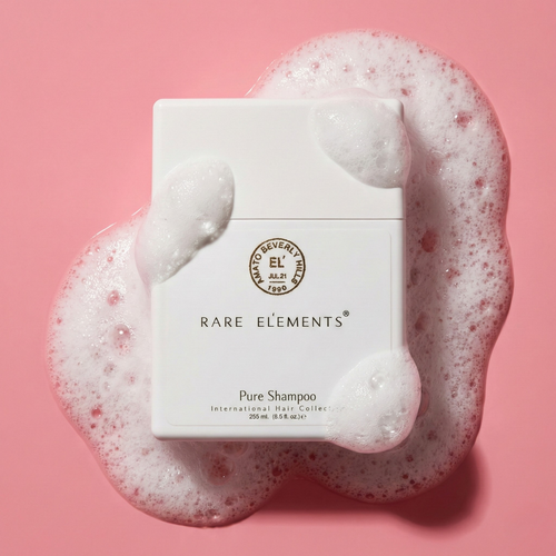 Rare Elements Pure Shampoo bottle with foam on a pink background